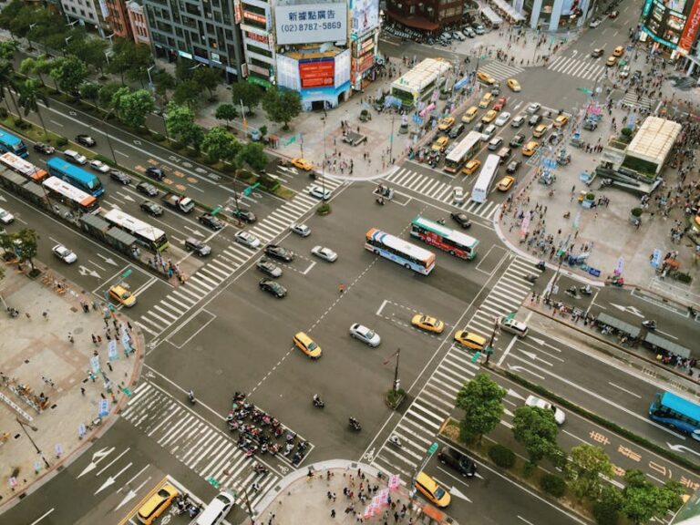 Aerial view showcasing busy city street life with traffic and pedestrians at an intersection.