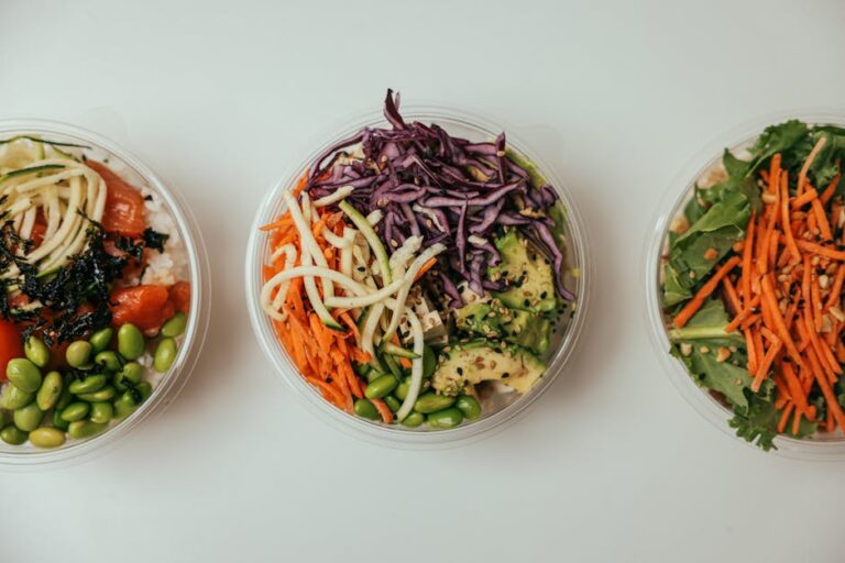 Top view of three healthy salad bowls featuring fresh mixed vegetables, perfect for a nutritious meal.